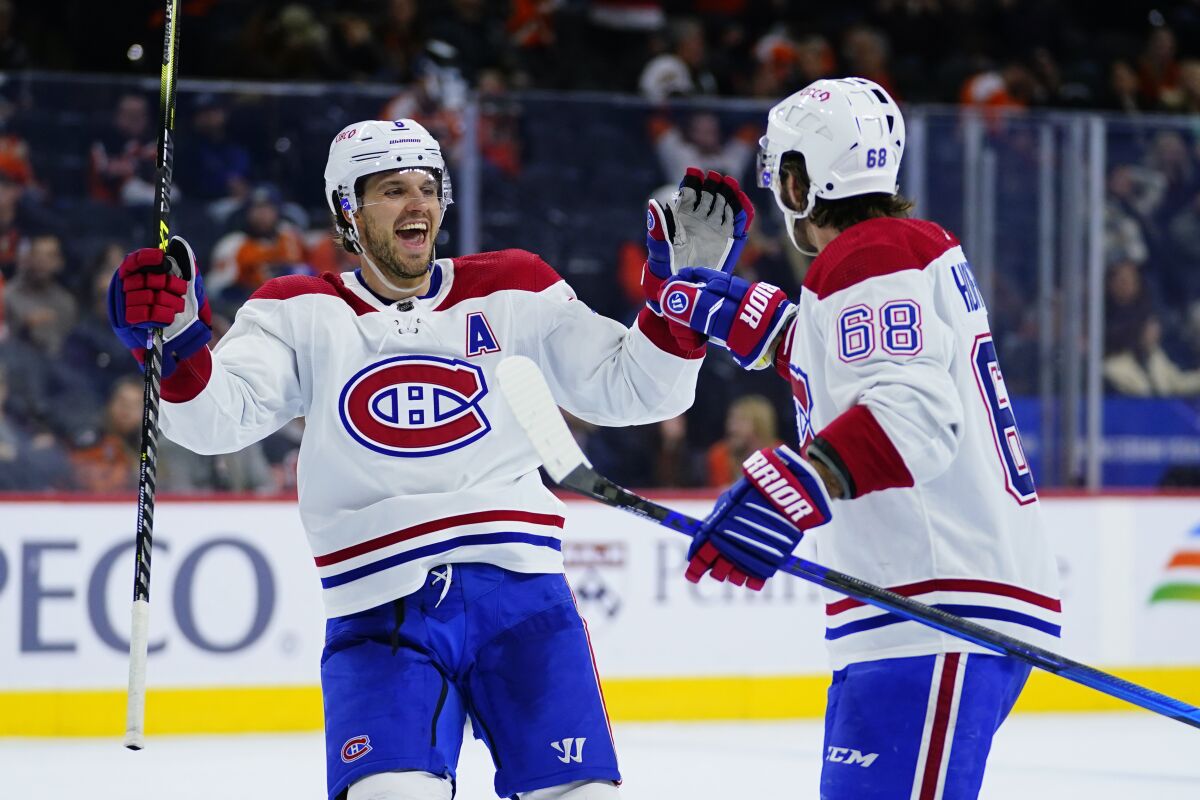 Montreal Canadiens' Ben Chiarot, left, and Mike Hoffman celebrate after a goal during the third period of an NHL hockey game against the Philadelphia Flyers, Sunday, March 13, 2022, in Philadelphia. (AP Photo/Matt Slocum)