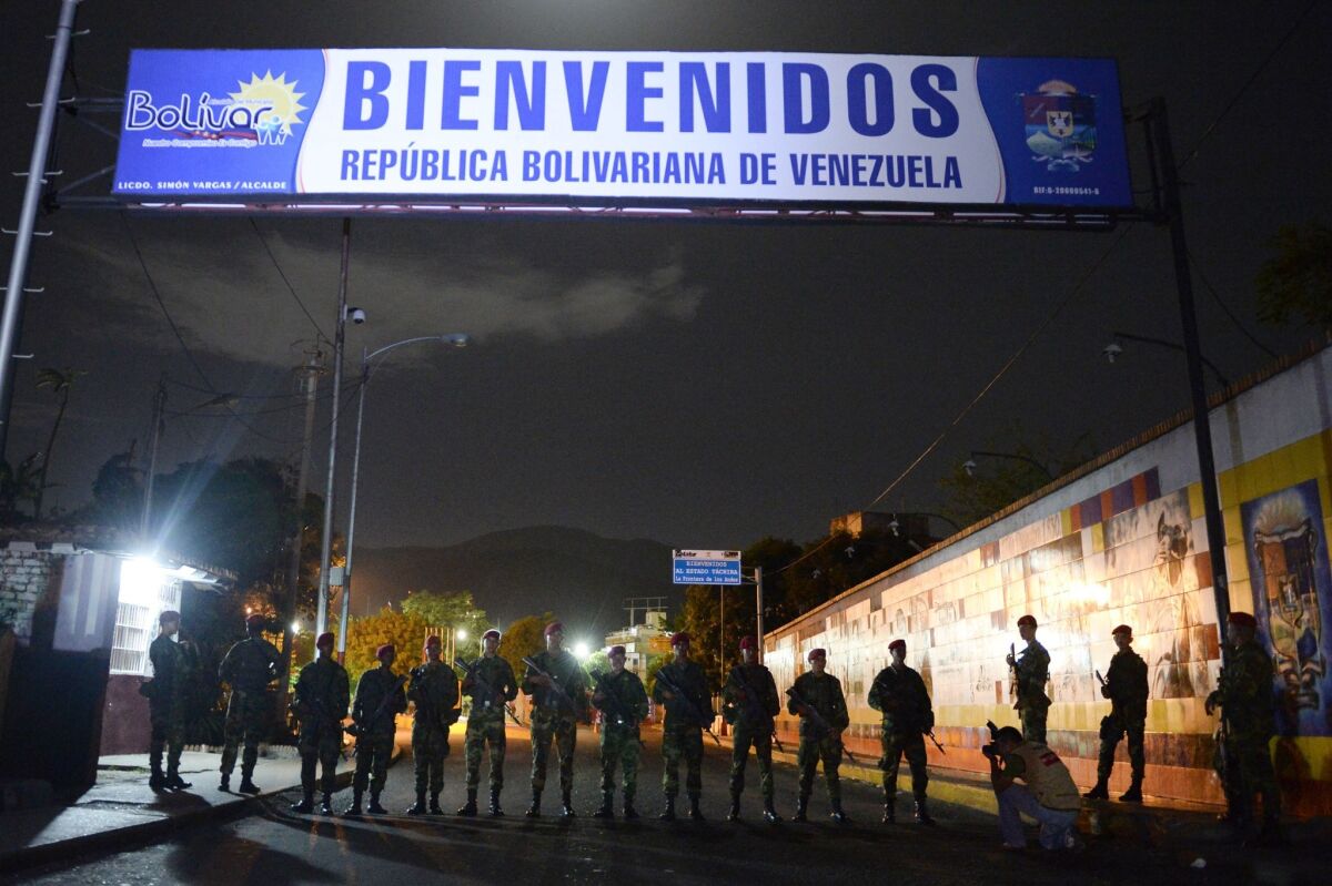 Venezuelan troops close the Venezuela-Colombia border in San Cristobal, Venezuela, on Monday night. The sign says, "Welcome: Bolivarian Republic of Venezuela."