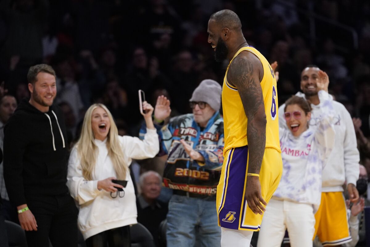 Lakers forward LeBron James smiles toward Rams quarterback Matthew Stafford and his wife, Kelly Stafford