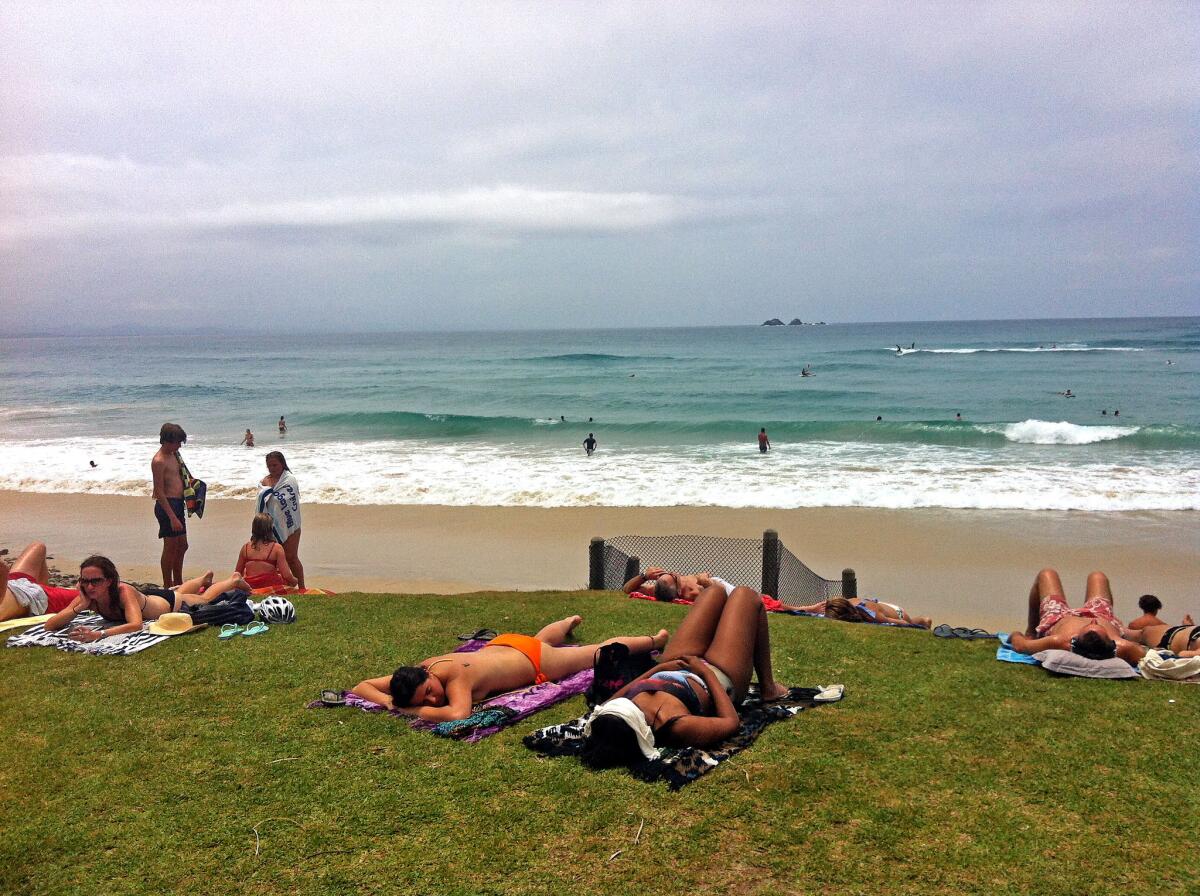 Swimmers get some sun at the beach in Byron Bay, Australia.