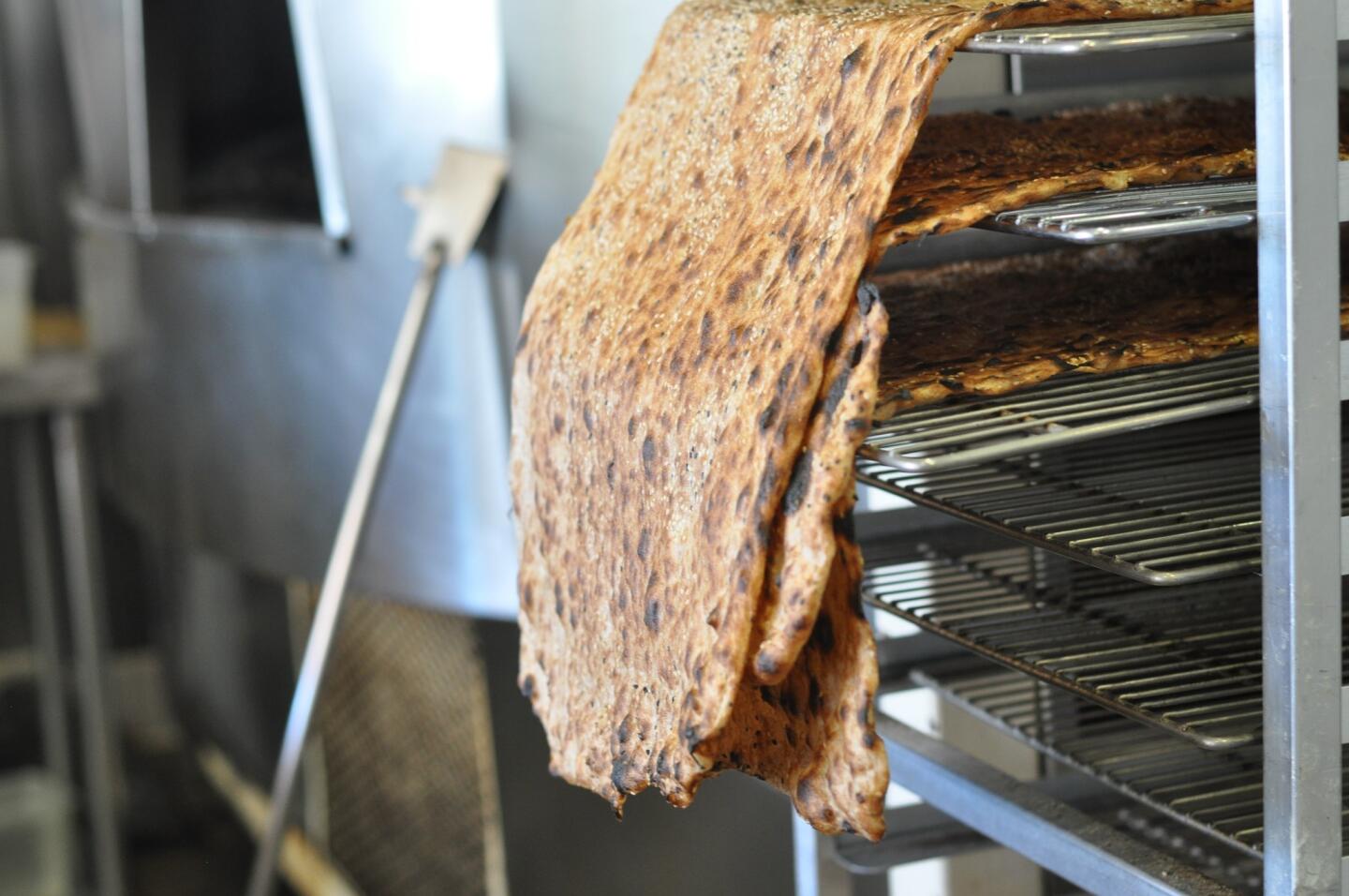 Racks of cooling sangak (flatbread) and the oven in which it's baked at Naan Hut.