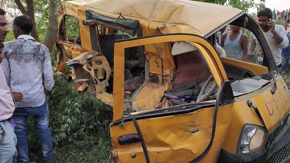 The mangled remains of a school van after it collided with a train in Kushinagar district in Uttar Pradesh, India.