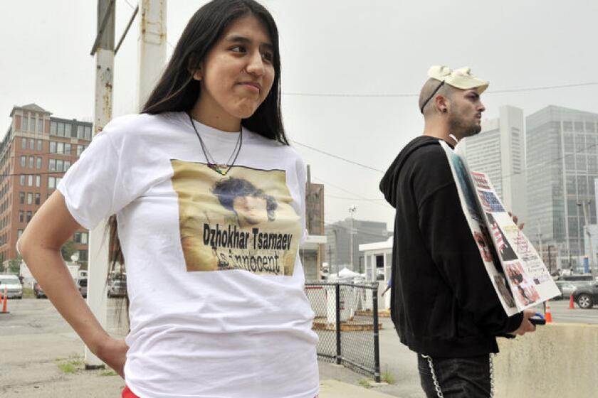 Jennifer Michio, left, from Mashantucket, Conn., and Duke La Touf, right, of Las Vegas, stand in support of Boston Marathon bombing suspect Dzhokhar Tsarnaev outside the federal courthouse before his arraignment Wednesday in Boston.