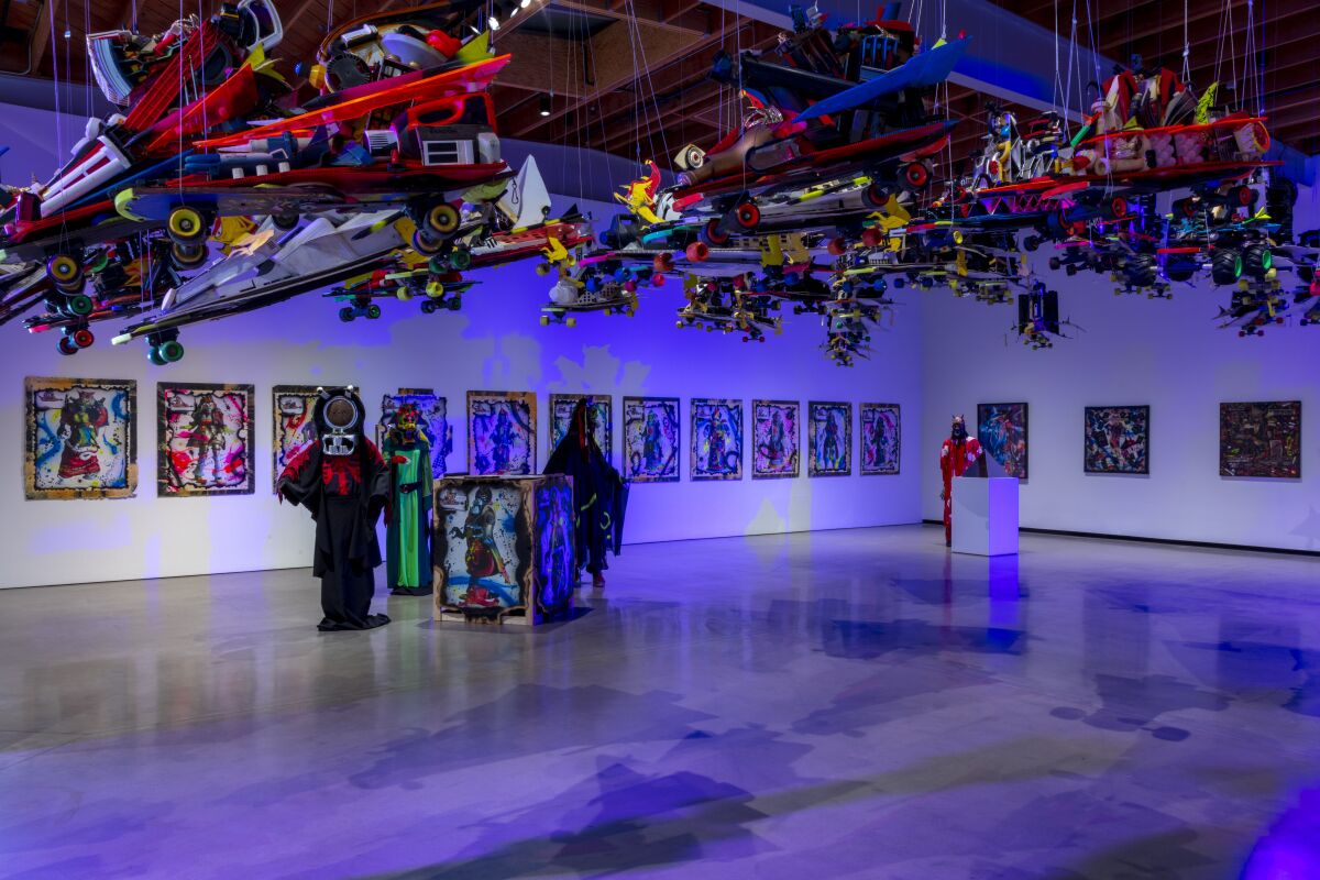 Installation view of paintings, costumes and skateboards.