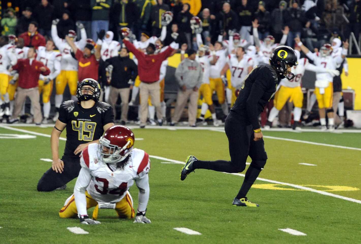 Oregon holder Jackson Rice (49) reacts, as well as the USC sideline in the background, after kicker Alejandro Maldonado missed a field-goal attempt that could have tied the score as time expired on Saturday at Autzen Stadium, giving the Trojans a 38-35 victory.