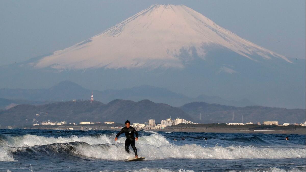 A man surfs in front of Japan's Mt. Fuji on April 5. Surfing will be among the events featured in the 2020 Tokyo Olympic Games.