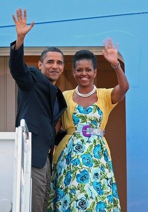 The Obamas wave from Air Force One before they leave Maryland's Andrews Air Force Base for a trip to Moscow. The boldly patterned floral dress and yellow cardigan were familiar elements of her look.