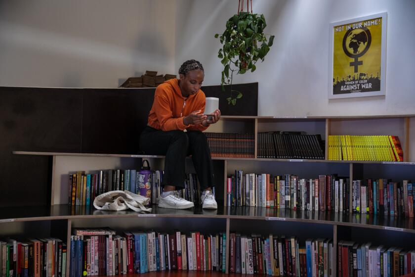 Los Angeles, CA - July 29: A woman enjoys her time at Noname book store in South LA, run by rapper Noname, holds an open mic night on Saturday, July 29, 2023 in Los Angeles, CA. (Jason Armond / Los Angeles Times)