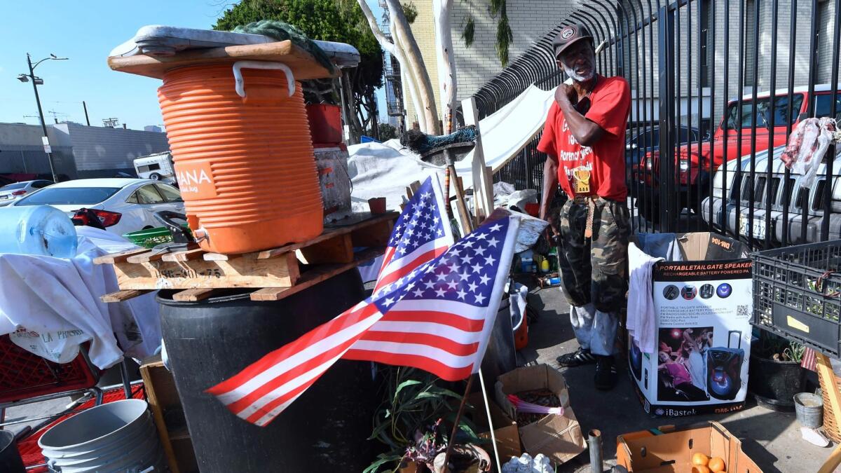 Flags are hoisted at the street-corner encampment of L.A. homeless veteran Kendrick Bailey.