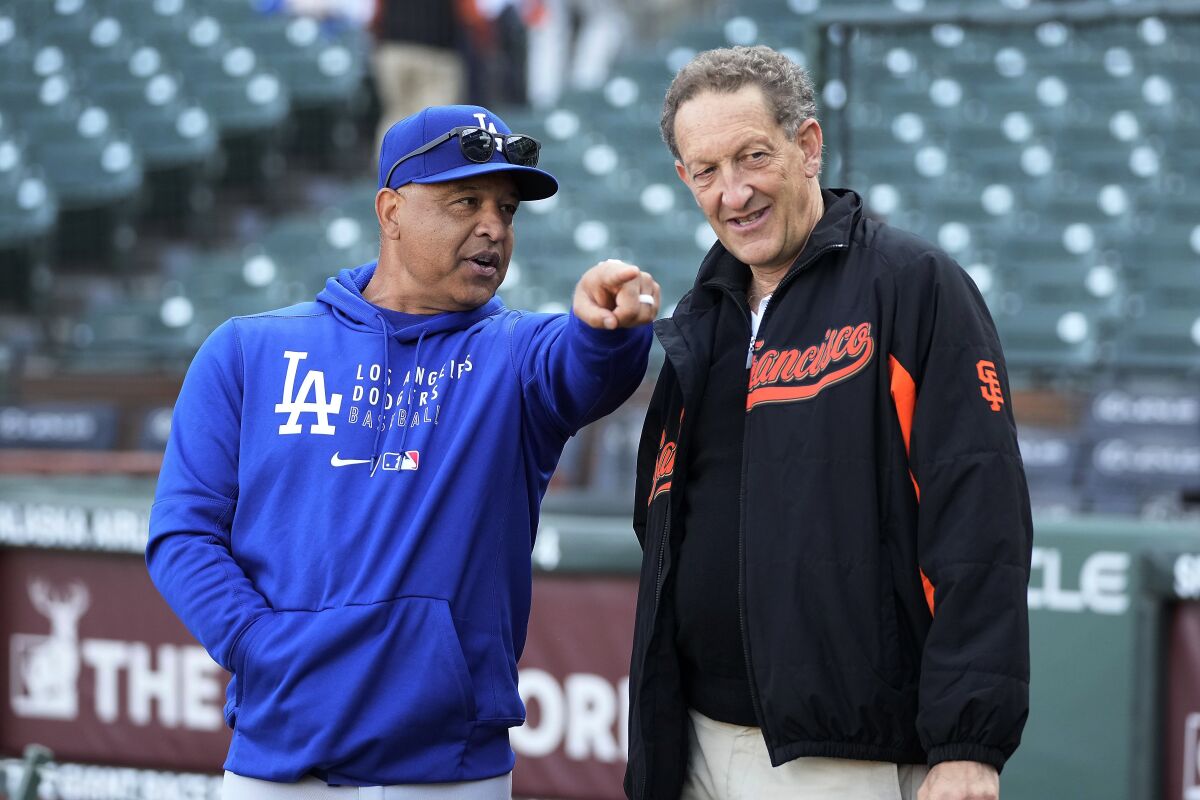 Dodgers manager Dave Roberts, left, talks with San Francisco Giants President Larry Baer.