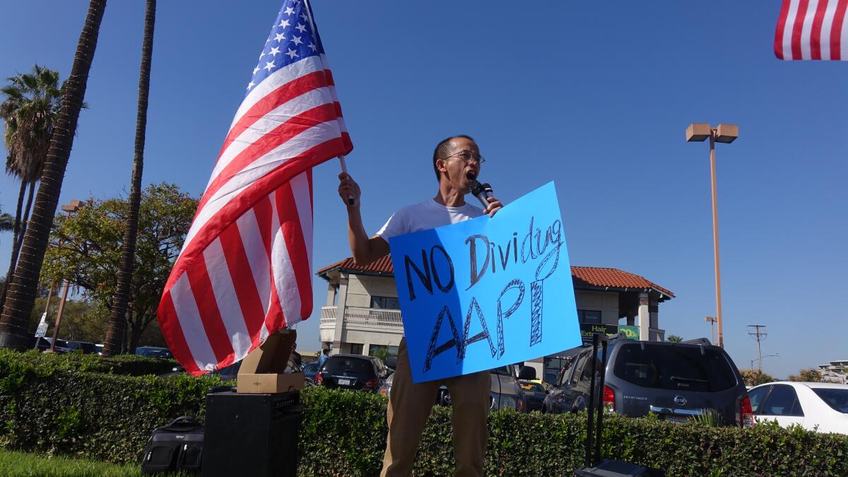Zig Jiang, 48, of Hacienda Heights, speaks during a protest outside of Rep. Michelle Steel's campaign office in Buena Park.