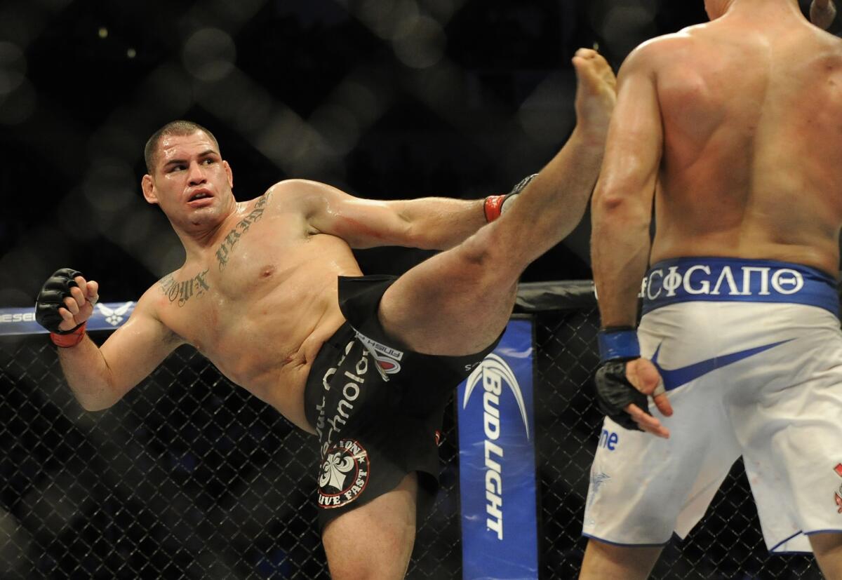 Cain Velasquez, left, defeated Junior Dos Santos on Saturday night to keep his UFC heavyweight belt.