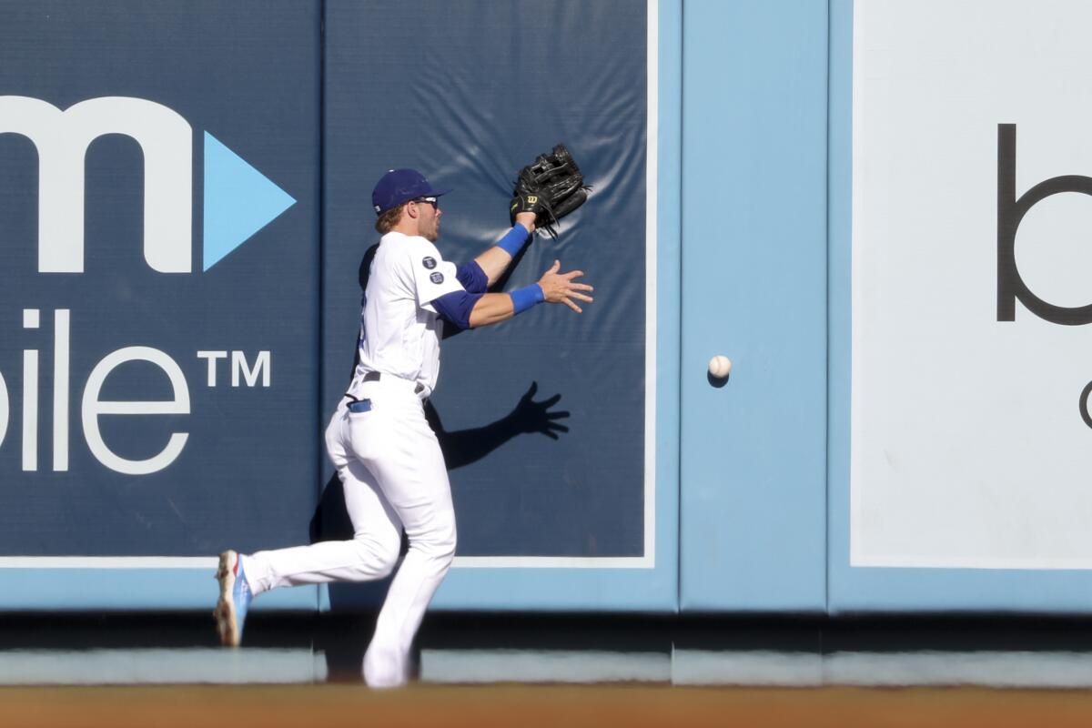 Dodgers center fielder Gavin Lux is unable to catch a fly ball hit by Atlanta's Austin Riley.