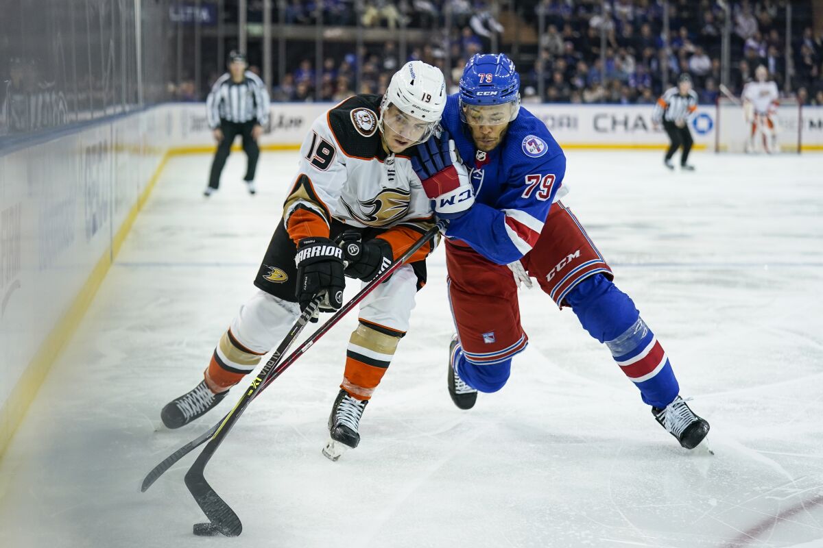 Ducks right wing Troy Terry and New York Rangers defenseman K'Andre Miller battle for the puck.