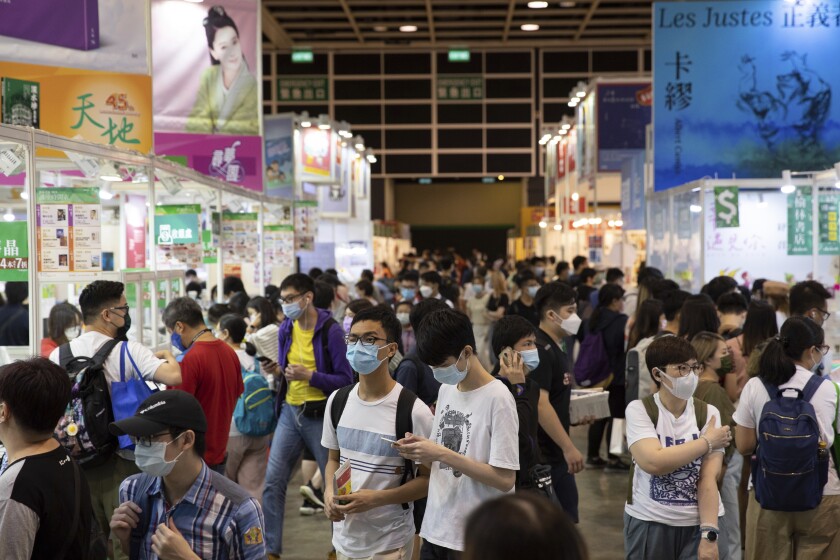 People visit the annual book fair in Hong Kong Wednesday, July 14, 2021. Booksellers at Hong Kong's annual book fair are offering a reduced selection of books deemed politically sensitive, as they try to avoid violating a sweeping national security law imposed on the city last year. (AP Photo/Matthew Cheng)