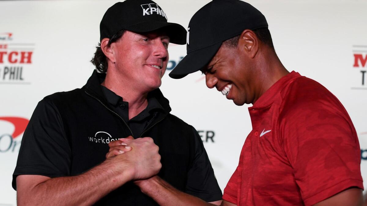 Phil Mickelson and Tiger Woods shake hands before their match Tuesday in Las Vegas.