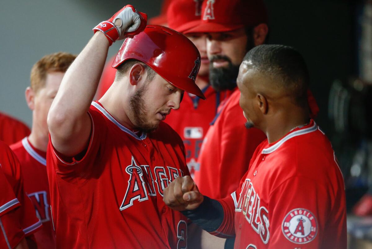 Angels designated hitter C.J. Cron, left, is congratulated by shortstop Erick Aybar after hitting a two-run home run against the Mariners in the sixth inning Friday night in Seattle.