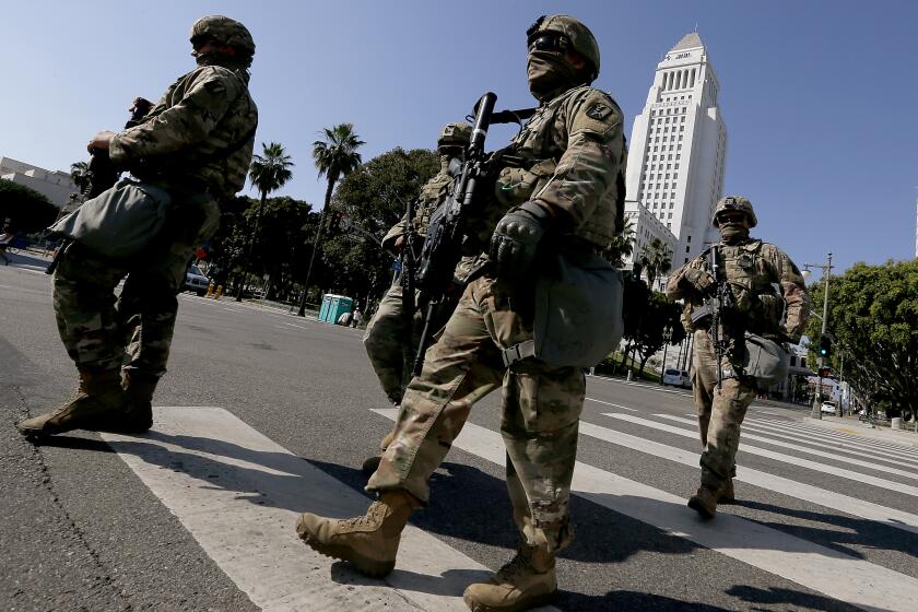 LOS ANGELES, CALIF. - JUNE 4, 2020. National Guardsmen cross the intersection of First and Main streets in downtown Los Angeles on Thursday, June 4, 2020, ahead of a large demonstration to demand justice for George Floyd, a black man killed by a white police officer in Minneapolis more than one week ago. Curfews have been lifted throughout L.A. County as mostly peaceful protests continue. (Luis Sinco/Los Angeles Times)