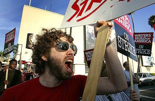Writer Asher Levin loudly walks the picket line outside the Warner Bros. studios in Burbank as the Writers Guild of America strike began in earnest this week.