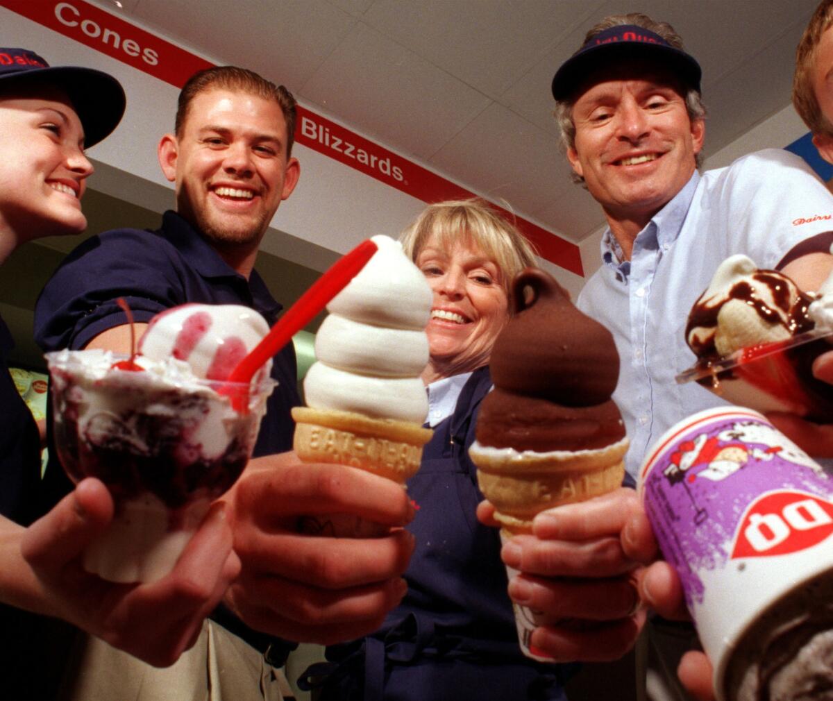 It's Free Cone Day at Dairy Queen. Pictured, from left, are Dairy Queen employees Molly Greene, Mike Hill, Kate Silverman, and her husband Rick, with various types of ice cream.