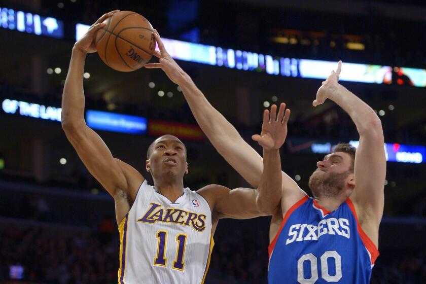 Philadelphia 76ers center Spencer Hawes, right, blocks a shot by Lakers guard Wesley Johnson during the first half of a game at Staples Center.