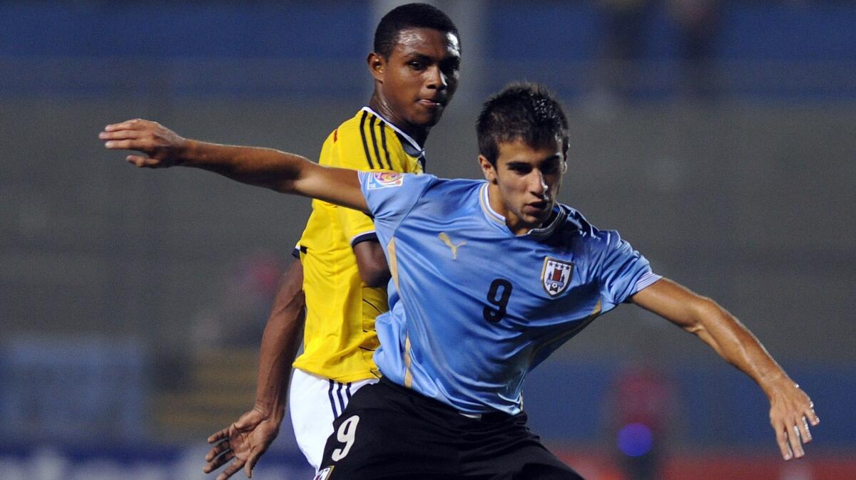 Uruguay's Diego Rossi, front, battles for the ball with Colombia's Jesus Marimon during a South American U-17 game in Asuncion, Paraguay, on March 20, 2015.