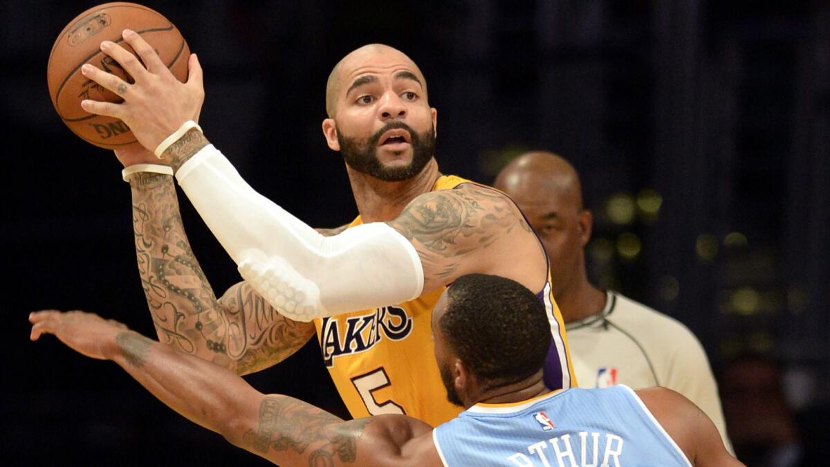 Lakers forward Carlos Boozer looks to pass over Denver Nuggets forward Darrell Arthur during a game on Feb. 10.