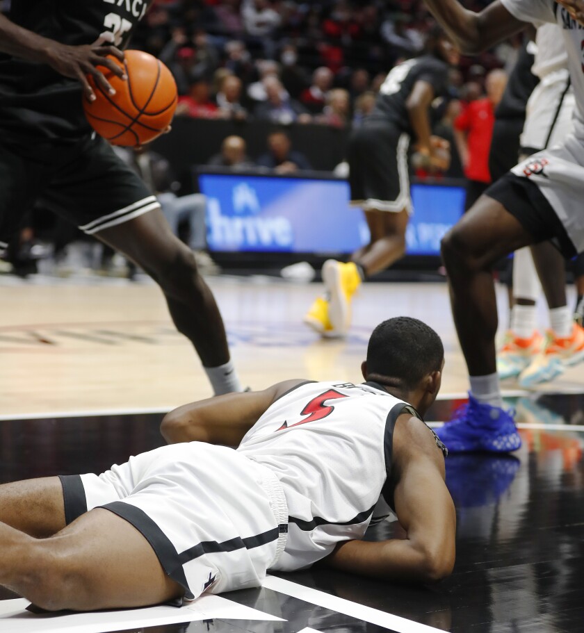 San Diego State's Lamont Butler falls to the ground after slamming the ball against Long Beach State on Tuesday.