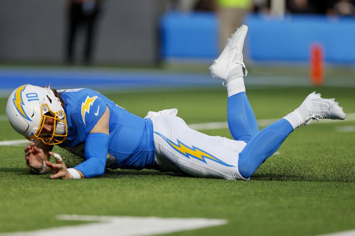 Quarterback Justin Herbert (10) is knocked to the turf in the Chargers' game against the Lions.