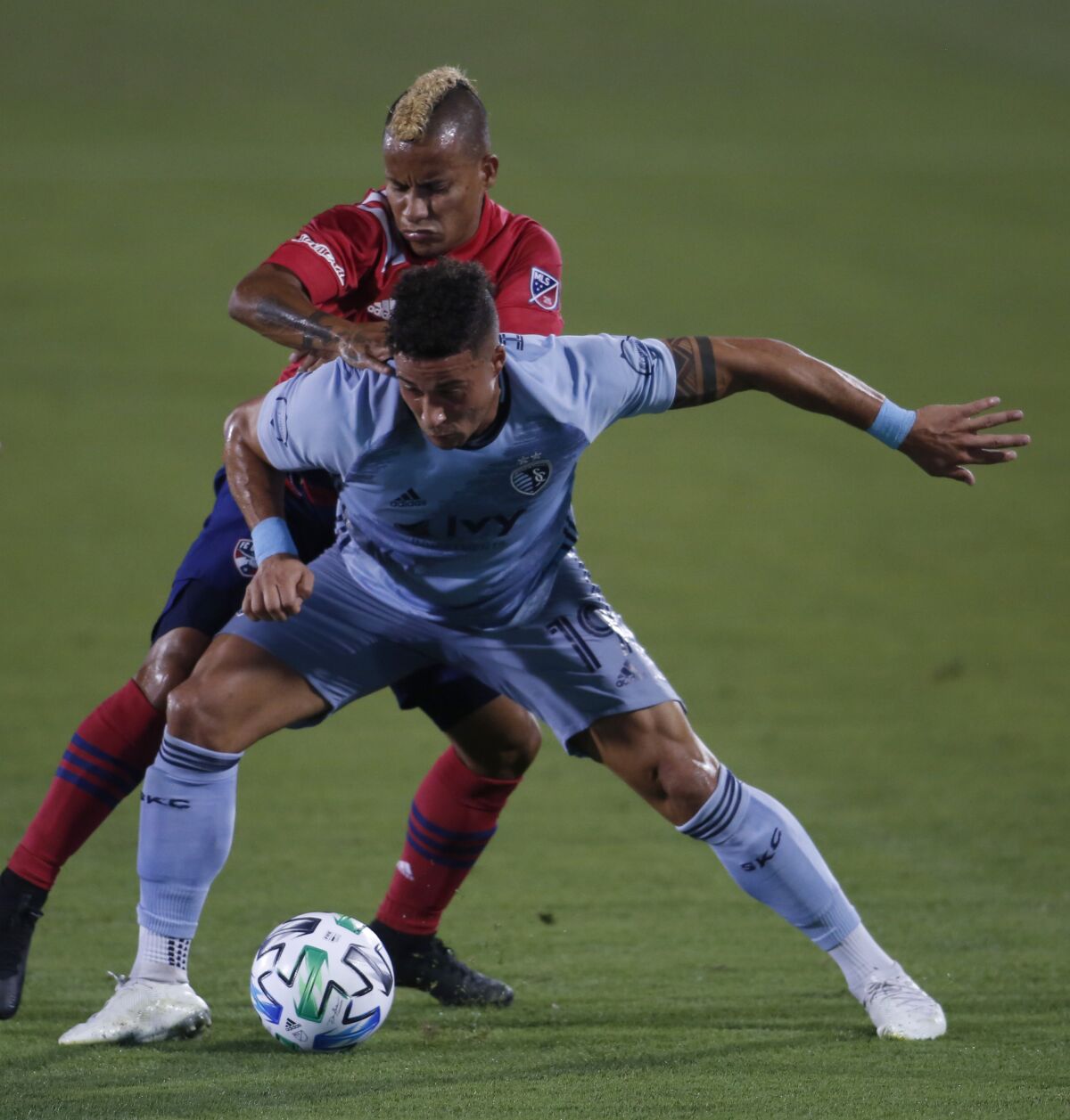 Sporting KC's Erik Hurtado, front, shields the ball from FC Dallas' Michael Barriosduring the first half of an MLS soccer game in Frisco, Texas, Wednesday, Oct. 14, 2020. (Steve Hamm/The Dallas Morning News via AP)