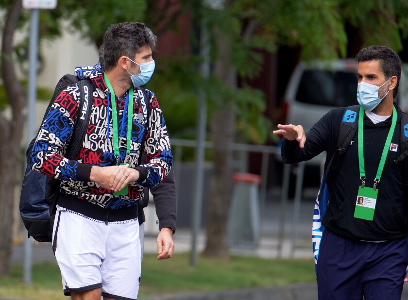 Pro tennis players Simone Bolelli and Maximo Gonzalez are escorted to their training session.