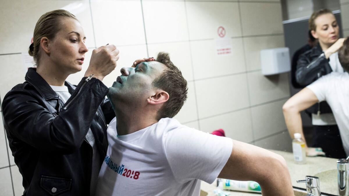 In a photo taken on April 27, 2017, Yulia, wife of Russian opposition leader Alexei Navalny, treats him after unknown attackers doused him with green antiseptic outside a conference venue in Moscow.