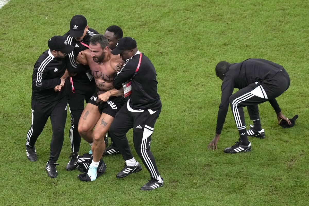 Agentes de seguridad retiran a un aficionado que invadió la cancha durante el partido entre Argentina y Holanda 