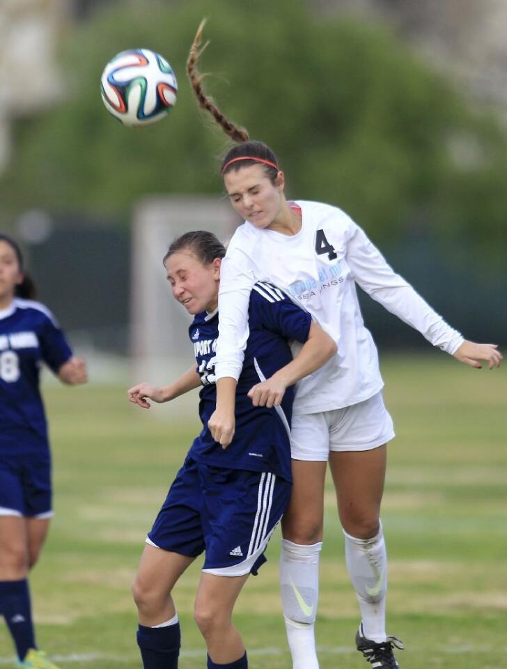 Corona del Mar High's Birkley Sigband (4) heads the ball over Newport Harbor's Toni Holland, left, during the second half in the Battle of the Bay match on Tuesday.