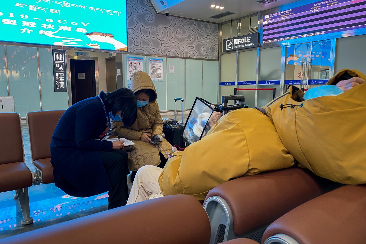 Airport workers took down medical information as some travelers slept in Garze airport on Feb. 15, 2020.