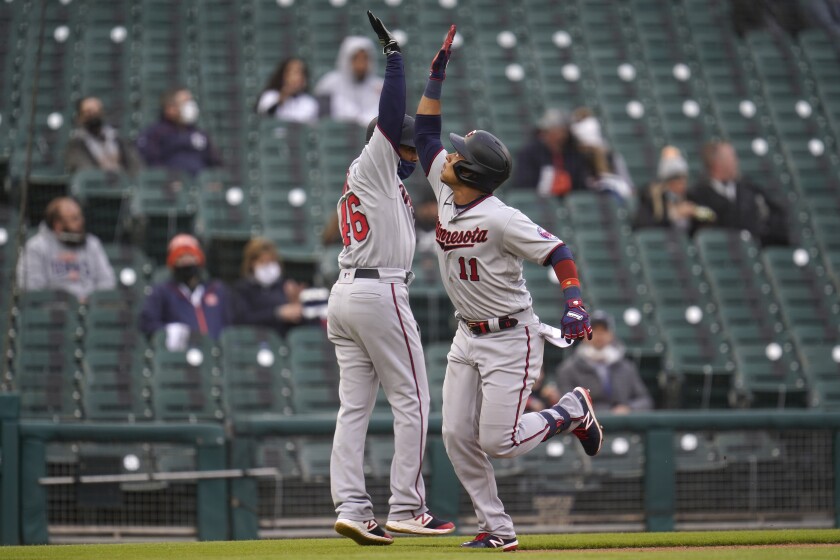 Minnesota Twins' Jorge Polanco (11) celebrates his solo home run with third base coach Tony Diaz (46) against the Detroit Tigers in the second inning of a baseball game in Detroit, Friday, May 7, 2021. (AP Photo/Paul Sancya)