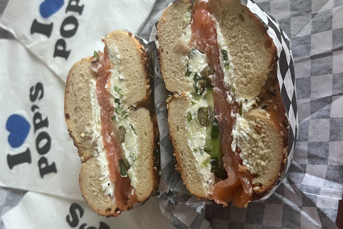 An everything bagel with lox, scallion cream cheese, capers, cucumbers, tomato and red onion.