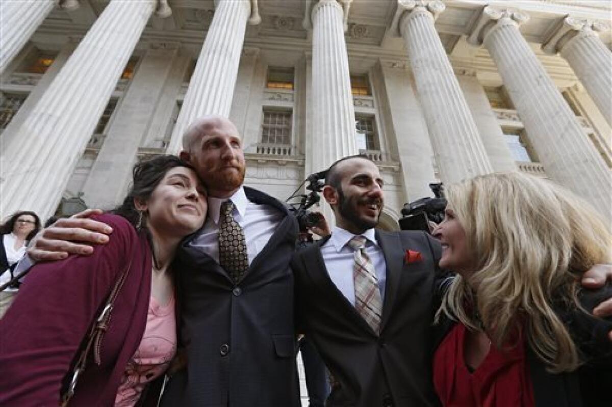 Plantiff Derek Kitchen, center left, and partner Moudi Sbeity hug relatives after the hearing.