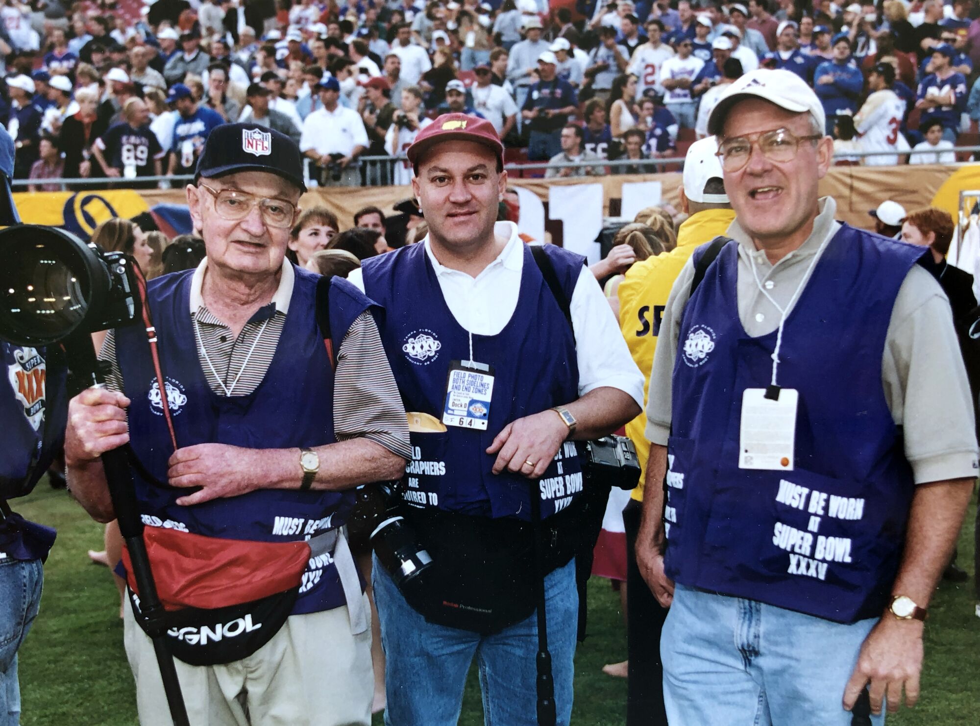Photographers Vernon Biever, left with his sons Jim and John stand on the sideline of Super Bowl 35 in Tampa in 2001