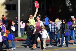 An Alhambra Unified School District crossing guard stops traffic for parents picking up their children from Ramona Elementary School on February 4, 2020 in Alhambra, California. - As the coronavirus outbreak spreads, fuelling rumors and misinformation, a petition to cancel all classes in one US school district for fear of the virus has garnered nearly 14,000 signatures. The online petition posted on Change.org urges the Alhambra Unified School District located east of Los Angeles and with a heavily Asian population, to basically shut down until the outbreak is over. School district officials, however, have dismissed the petition as a bid to whip up hysteria over the deadly outbreak that has killed hundreds in China. (Photo by Frederic J. BROWN / AFP) (Photo by FREDERIC J. BROWN/AFP via Getty Images)