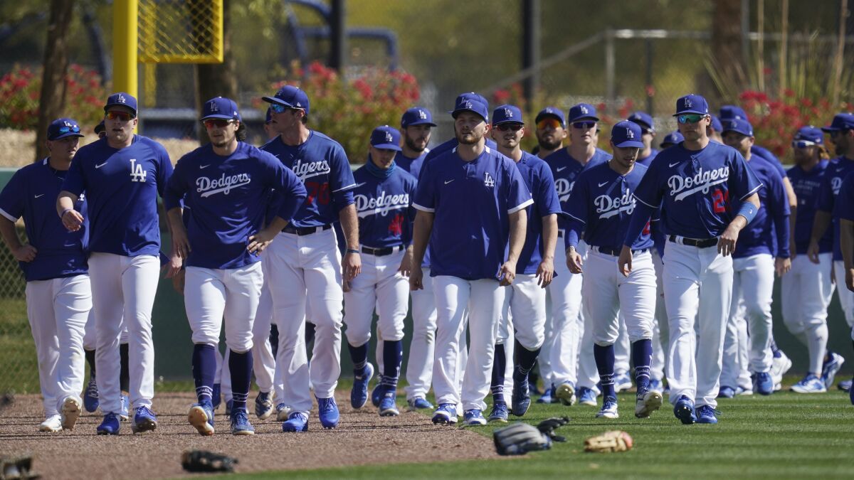 Dodgers players walk back to the infield after running sprints.