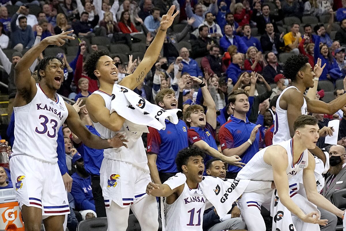 Kansas players celebrate after a teammate's basket during the second half of an NCAA college basketball game against UTEP Tuesday, Dec. 7, 2021, in Kansas City, Mo. (AP Photo/Charlie Riedel)