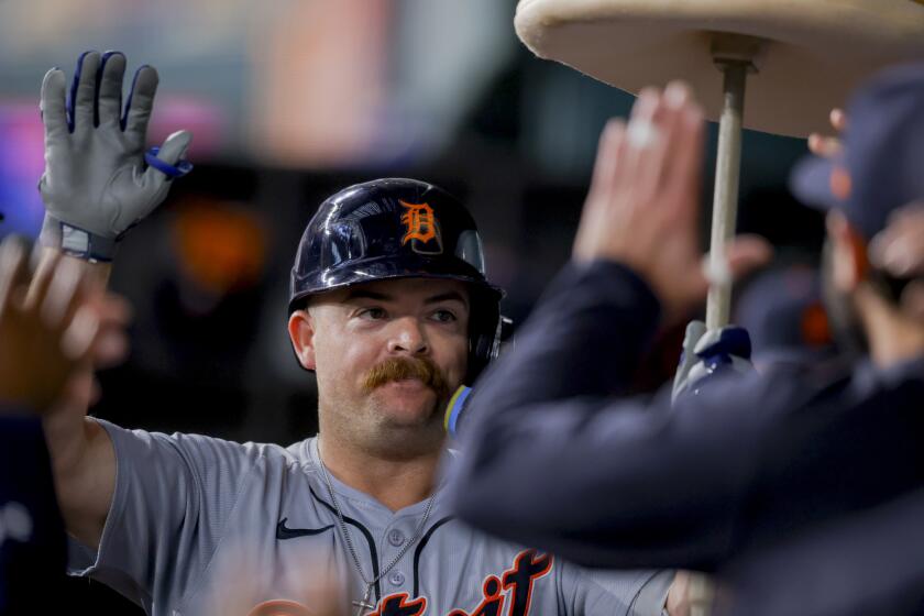 Detroit Tigers' Jake Rogers celebrates in the dugout with teammates after hitting a home run during the third inning of a baseball game against the Texas Rangers, Monday, June 3, 2024, in Arlington, Texas. (AP Photo/Gareth Patterson)
