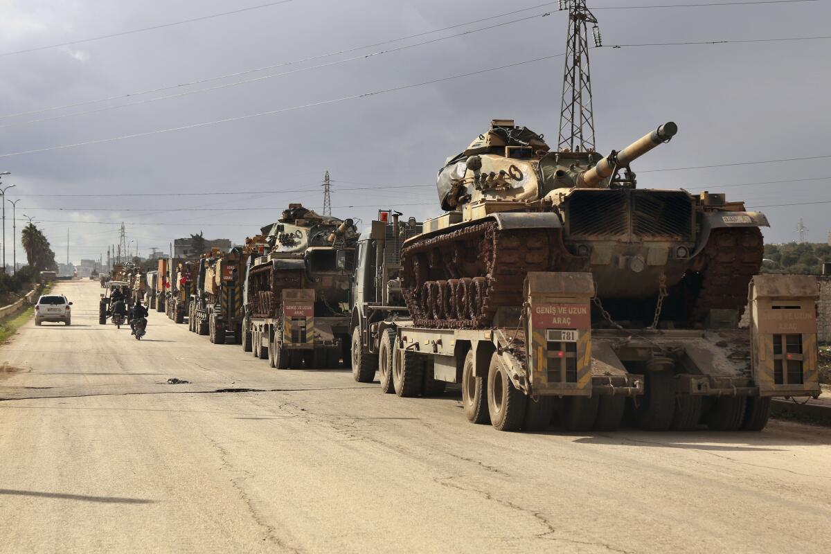 A Turkish military convoy drives through the village of Binnish, in Idlib province, Syria, on Saturday.