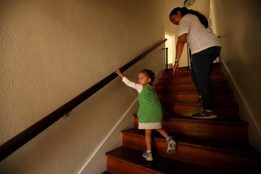 FYI EDITOR: THIS IMAGE IS FOR A RUBEN VIVES STORY ON RENTERS. LOS ANGELES, CA - SEPTEMBER 27, 2022 - - Heidi Gonzalez, 32, keeps an eye on her daughter Sarita, 2, while climbing the stairs to their apartment in Koreatown on September 27, 2022. At this time Gonzalez says her landlord was trying to kick her out of her apartment for falling behind in rent. She said that she fell behind in rent due to the landlord harassing her and taking drastic measures to force her out of the apartment. Once she moved in earlier in this year, the landlord was trying to get her to move out of the apartment. Gonzalez believes he was trying to get her out of the apartment so he could raise the rent with new tenants. Los Angeles renters have been concerned with the COVID-19 Tenant Protections Resolution coming to an end on December 31, 2022. (Genaro Molina / Los Angeles Times)
