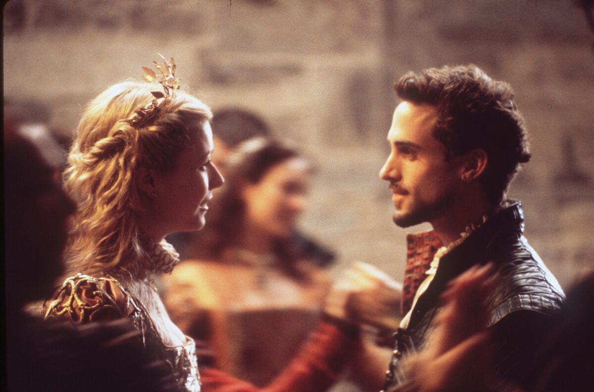 A woman and man in Elizabethan attire face each other.