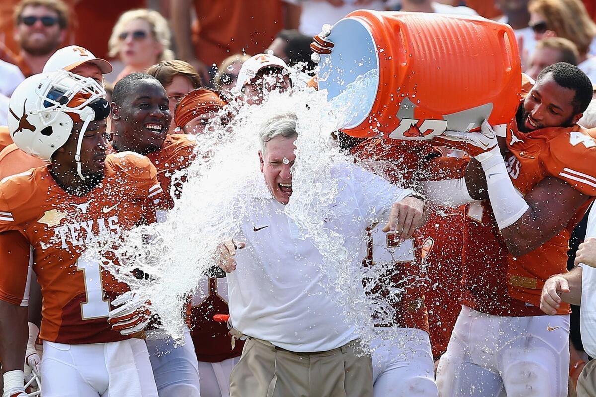 Texas Coach Mack Brown receives a celebratory ice-water shower following the Longhorns' 36-20 victory over Oklahoma on Saturday.