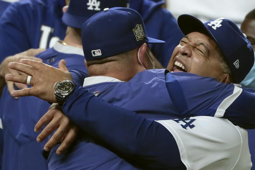 Arlington, Texas, Tuesday, October 27, 2020 Dodgers manager Dave Roberts celebrates with the team after clinching the World Series at Globe Life Field. (Robert Gauthier/ Los Angeles Times)