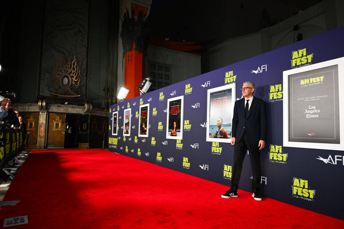 A man stands alone on a red carpet.