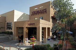 Vroman's Bookstore in Pasadena, a cube-like building with angular columns, painted a Spanish brown, customers walk by 